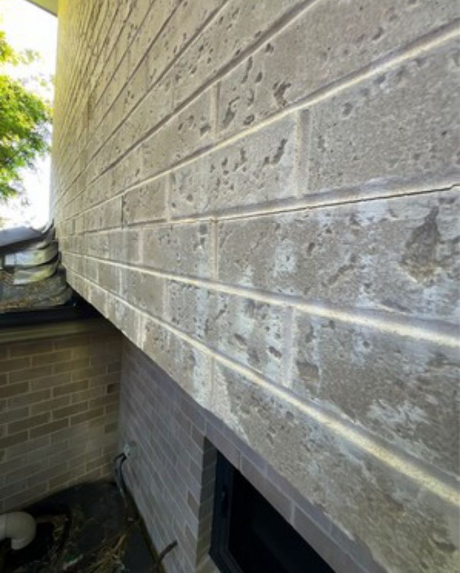 Looking along an upper-floor brick wall with courses visibly out of alignment