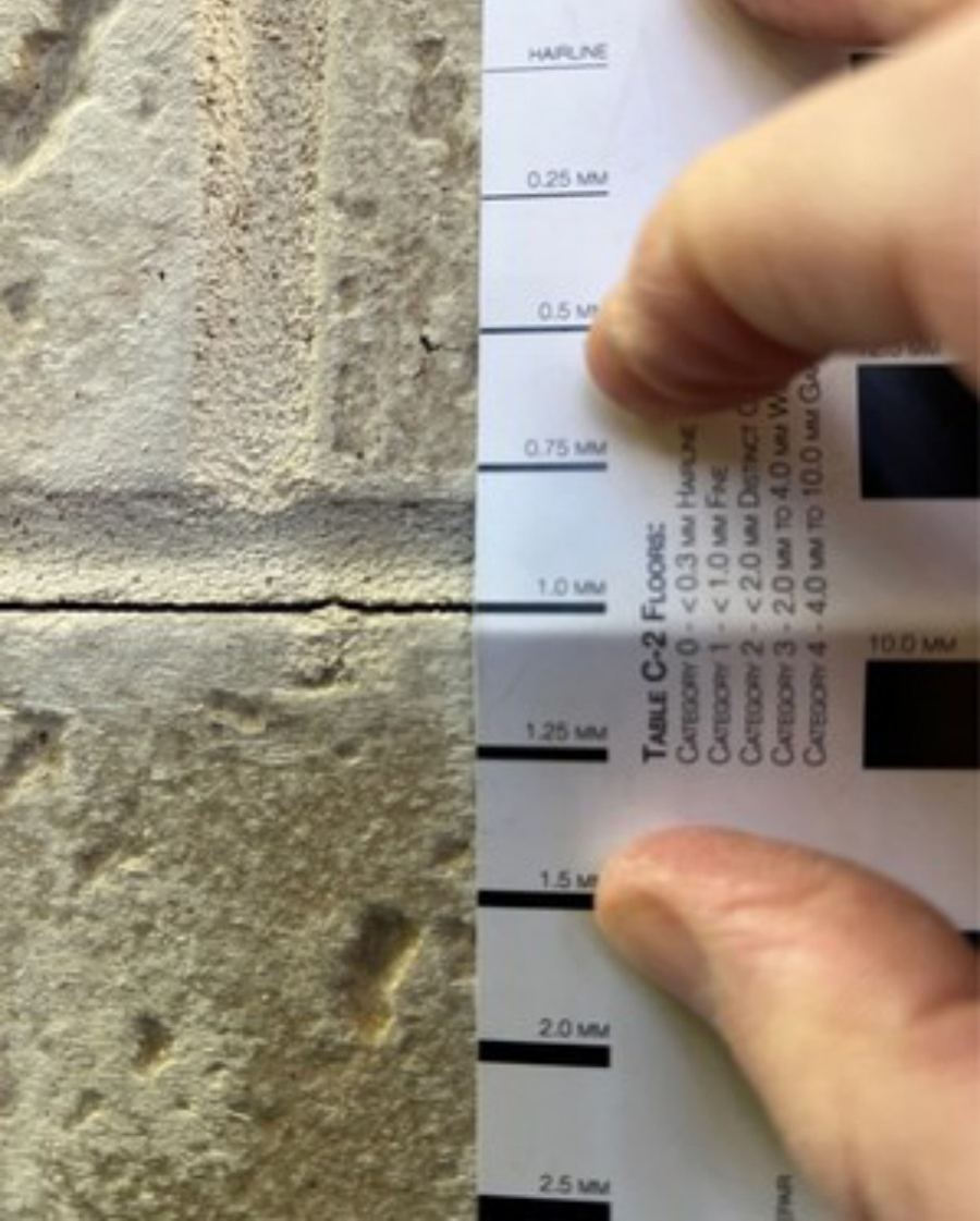 Crack width gauge held against a cracked mortar joint