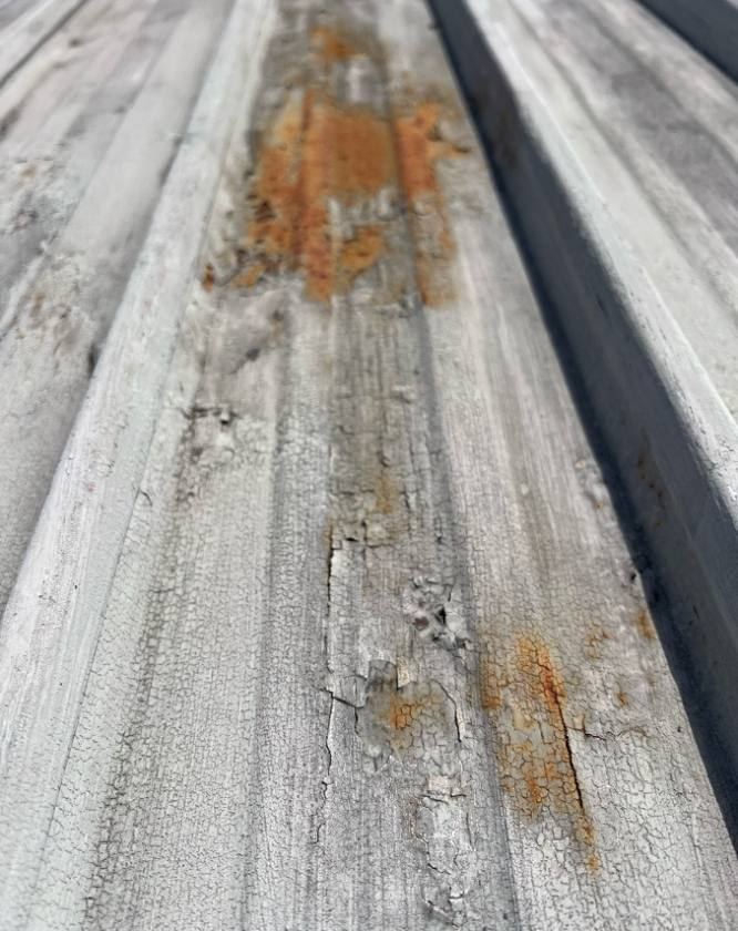 Roof sheet ribs with peeling paint and rust