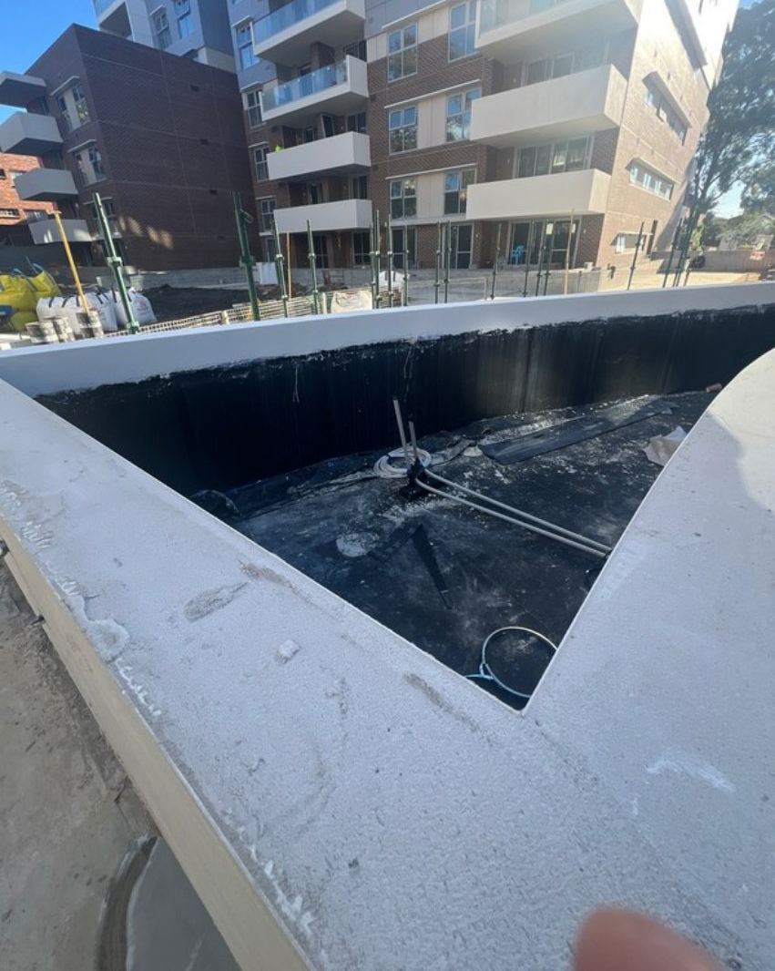 Raised podium garden bed lined with black sheet membrane